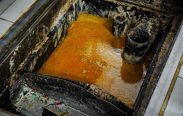 foul odors, slow drainage, and visible grease build-up are all signs that your grease trap may need cleaning